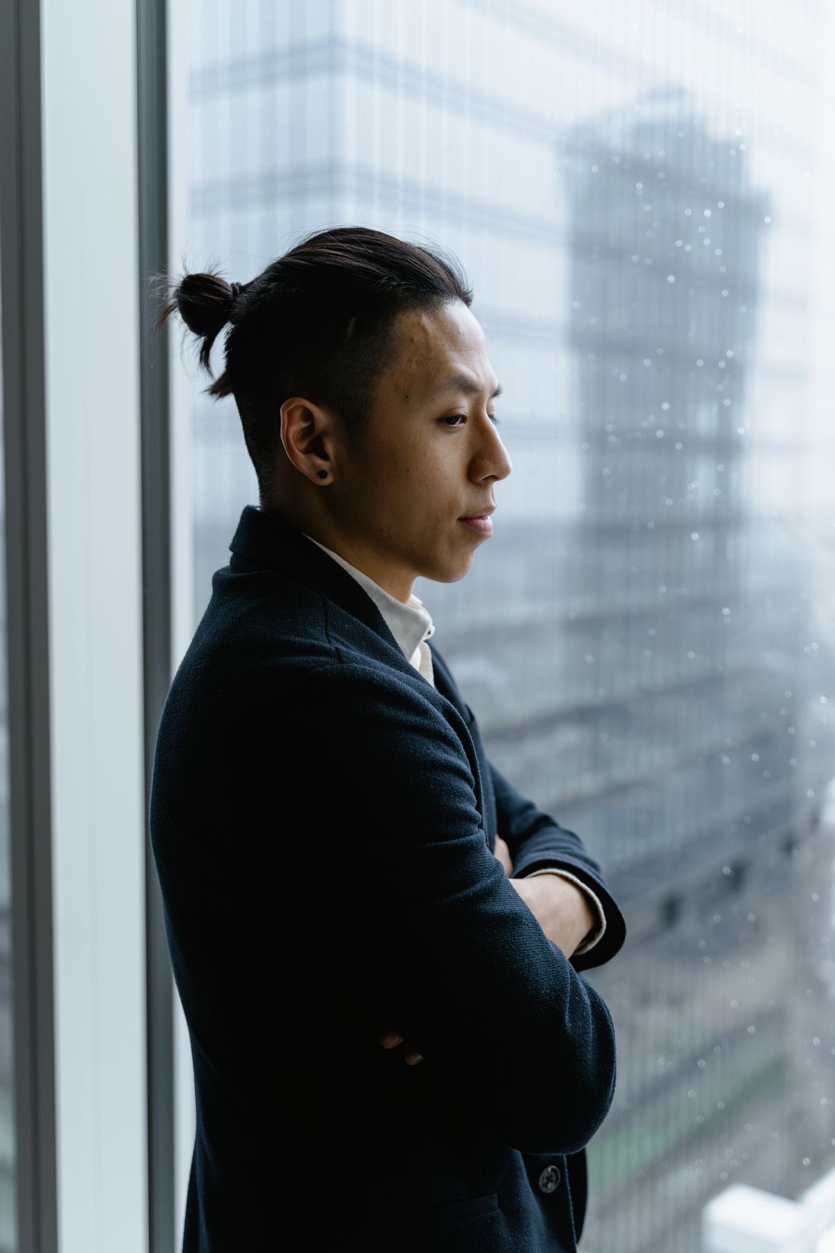 Calgary corporate professional standing thoughtfully by a high-rise office window