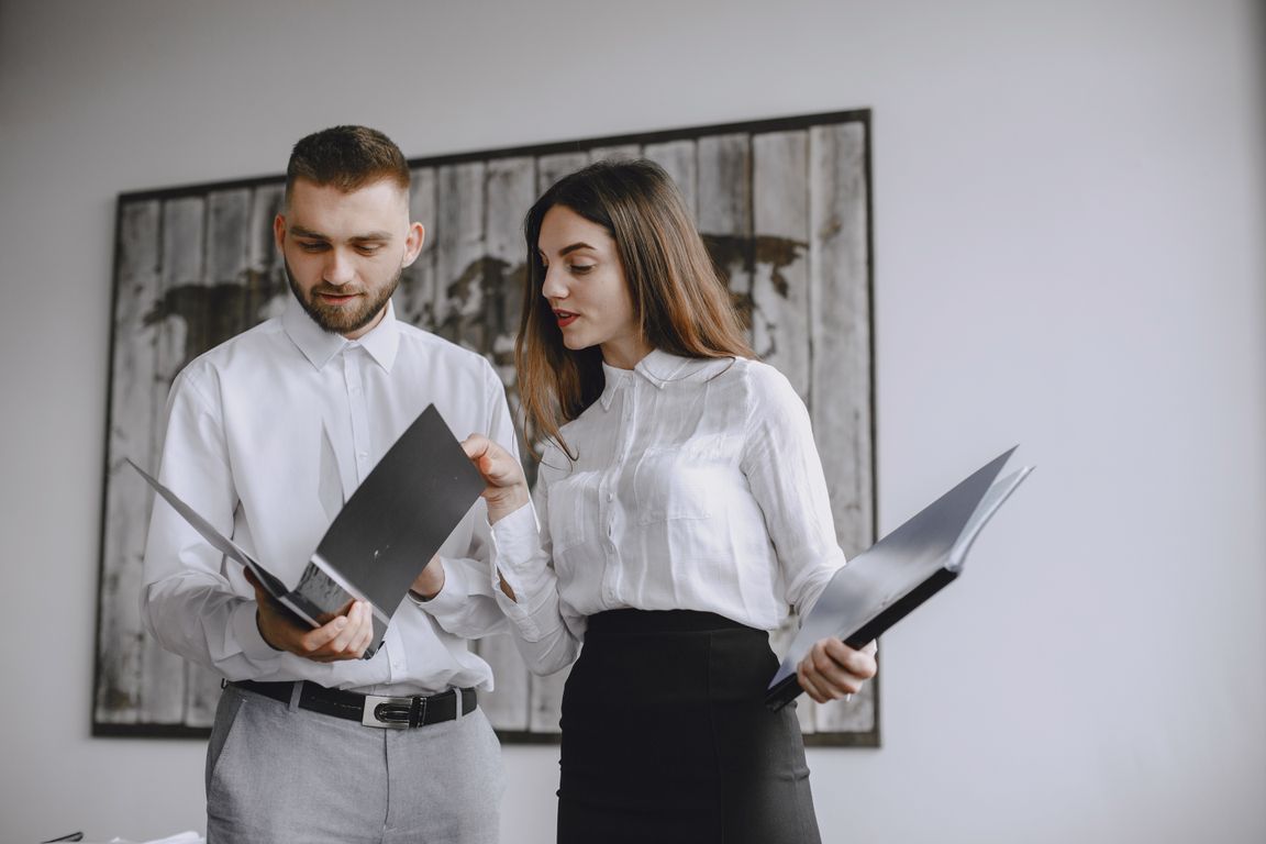 Two colleagues reviewing documents together in an office.